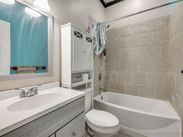 full bathroom featuring vanity, shower / bath combination with curtain, and toilet