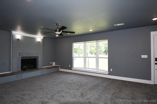 unfurnished living room with ceiling fan, carpet floors, and a brick fireplace