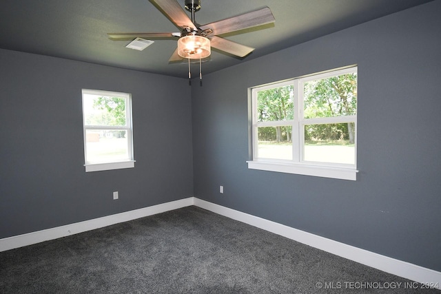 empty room featuring ceiling fan and dark carpet