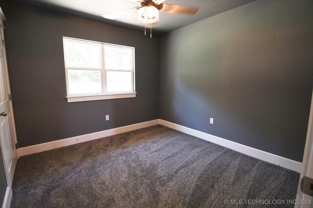 unfurnished room with ceiling fan and carpet