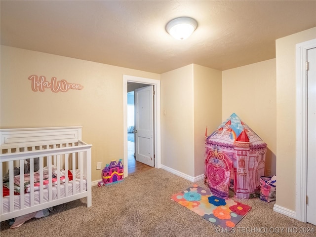 bedroom featuring carpet and a nursery area