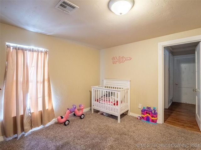 unfurnished bedroom with carpet floors and a nursery area