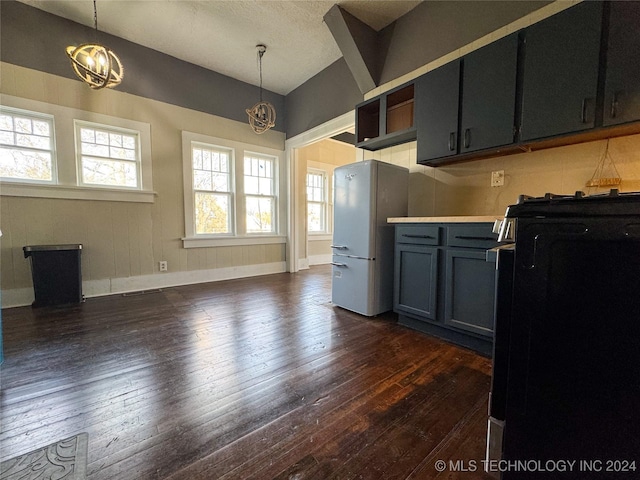 kitchen with decorative light fixtures, an inviting chandelier, and dark wood-type flooring