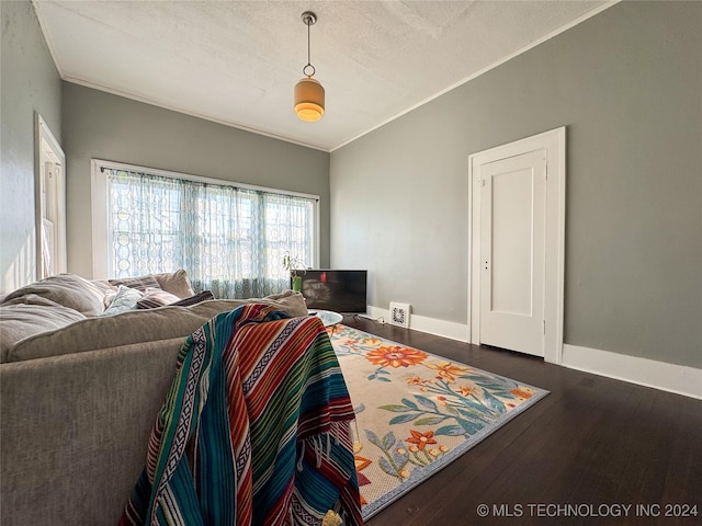 bedroom with dark hardwood / wood-style floors, ornamental molding, and a textured ceiling