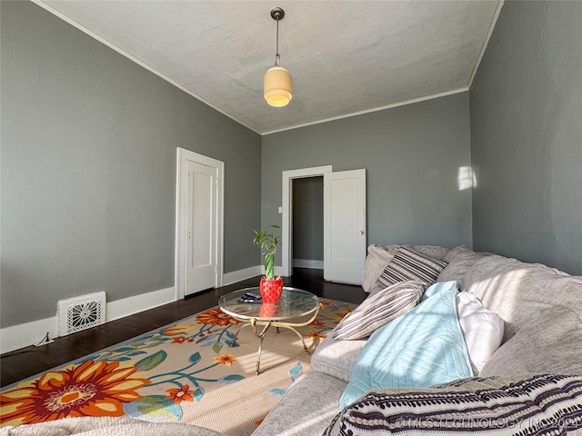 interior space with a textured ceiling, crown molding, and dark wood-type flooring