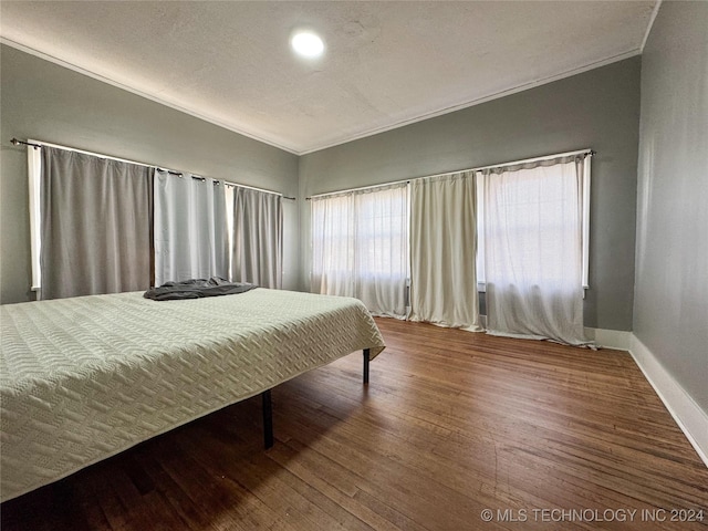 bedroom featuring wood-type flooring and ornamental molding