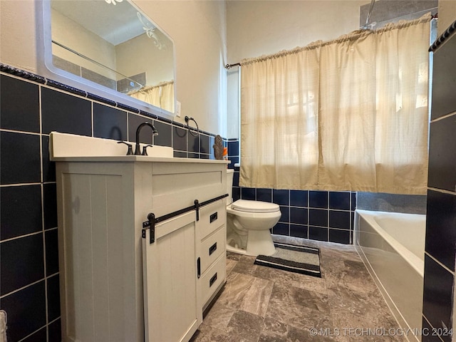 full bathroom with vanity, toilet, tile walls, and shower / tub combo with curtain