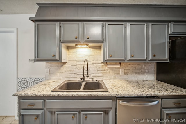 kitchen featuring gray cabinetry, dishwasher, and sink