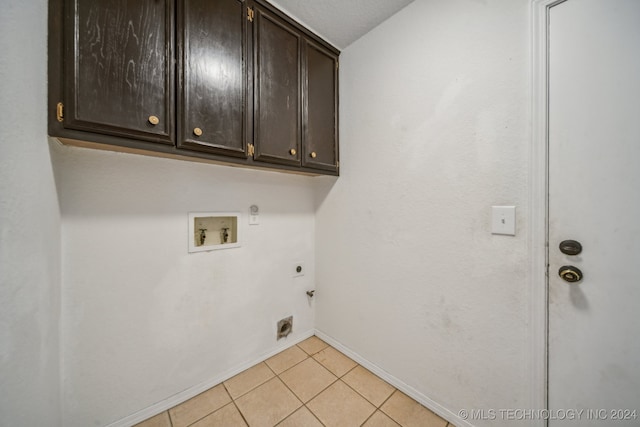 laundry room with cabinets, electric dryer hookup, hookup for a gas dryer, hookup for a washing machine, and light tile patterned floors