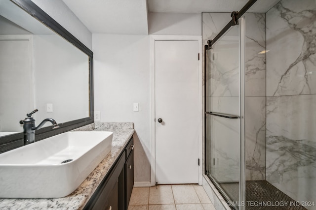 bathroom with tile patterned flooring, vanity, and walk in shower