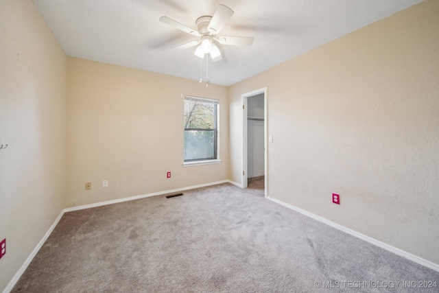 carpeted spare room with ceiling fan