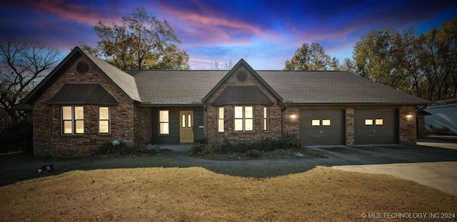 view of front of property with a garage and a lawn