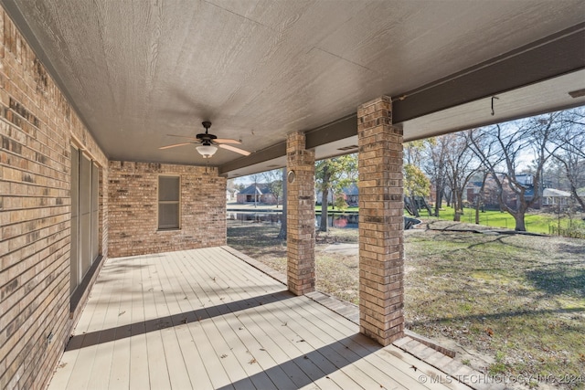 wooden deck featuring ceiling fan and a yard