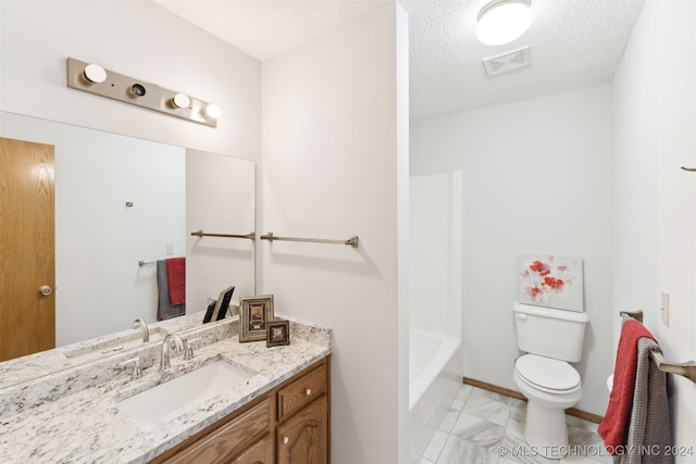 bathroom featuring vanity, toilet, and a textured ceiling