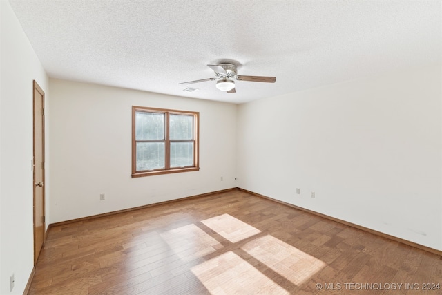 unfurnished room featuring a textured ceiling, light hardwood / wood-style flooring, and ceiling fan