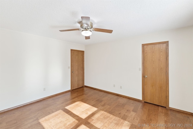 unfurnished room featuring wood-type flooring, a textured ceiling, and ceiling fan