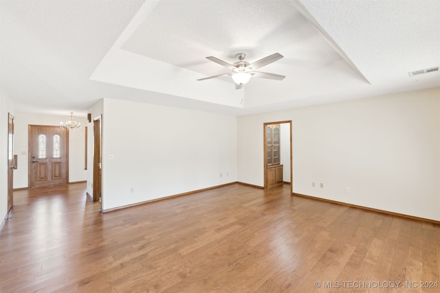 spare room with ceiling fan with notable chandelier, wood-type flooring, and a textured ceiling