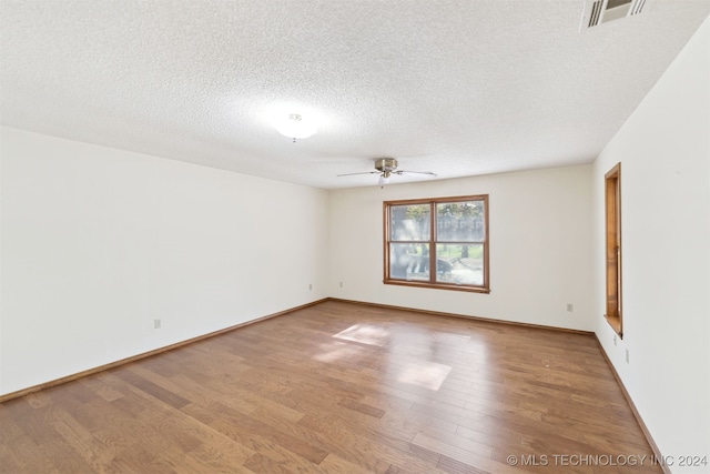 spare room with a textured ceiling, hardwood / wood-style flooring, and ceiling fan