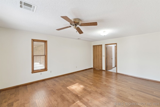 empty room featuring ceiling fan, a textured ceiling, and light hardwood / wood-style flooring