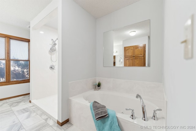 bathroom with plus walk in shower and a textured ceiling