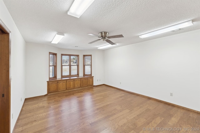 unfurnished room with a textured ceiling, light hardwood / wood-style flooring, and ceiling fan