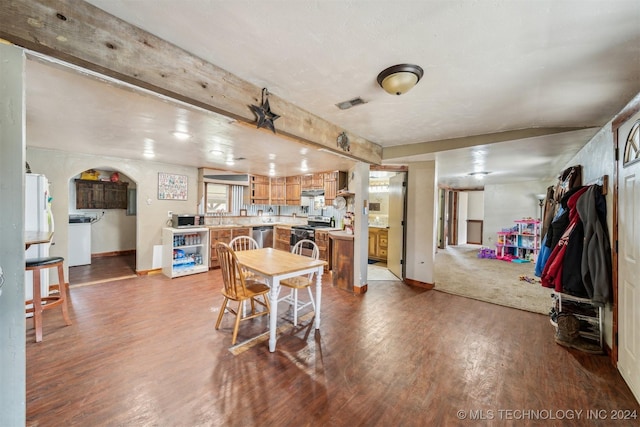 dining area with hardwood / wood-style flooring, sink, and beamed ceiling