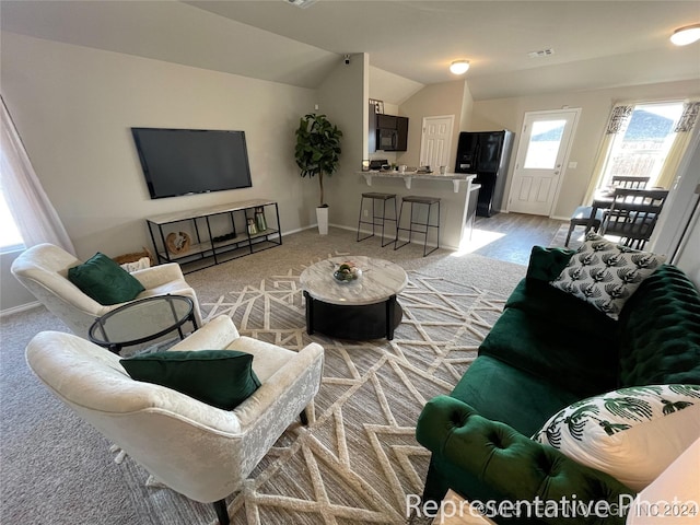 carpeted living room with lofted ceiling