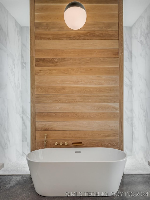 bathroom with wood walls and a bath