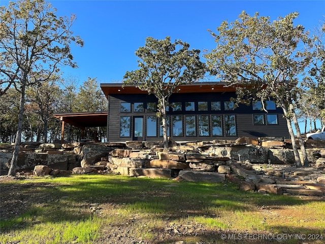 rear view of property with a yard