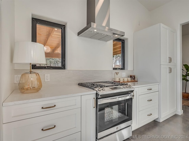 kitchen with white cabinets, gas stove, a wealth of natural light, and wall chimney range hood