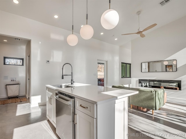 kitchen featuring pendant lighting, a kitchen island with sink, white cabinets, sink, and stainless steel dishwasher