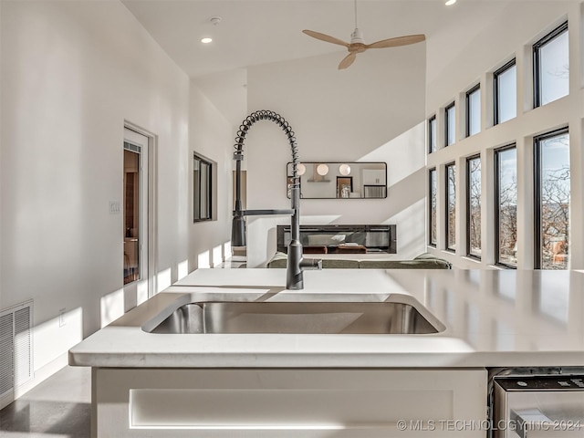 kitchen with ceiling fan, sink, and high vaulted ceiling