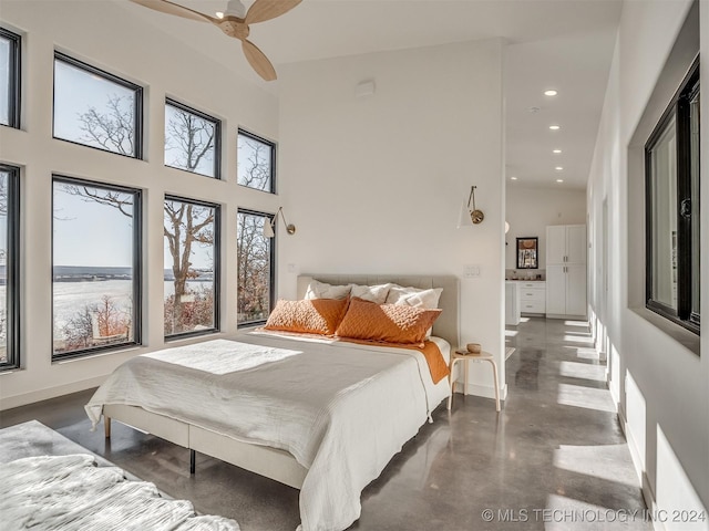 bedroom with ceiling fan and a towering ceiling