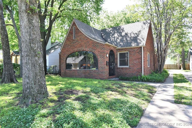 english style home featuring a front lawn