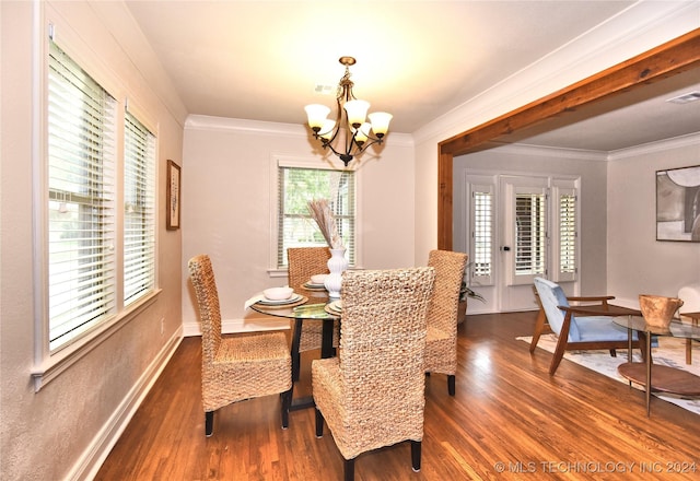 dining room featuring dark hardwood / wood-style flooring, ornamental molding, and a chandelier