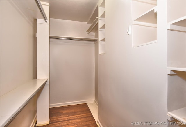 walk in closet with dark hardwood / wood-style flooring