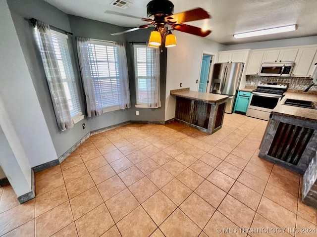 kitchen featuring stainless steel fridge, electric range oven, white cabinetry, and sink