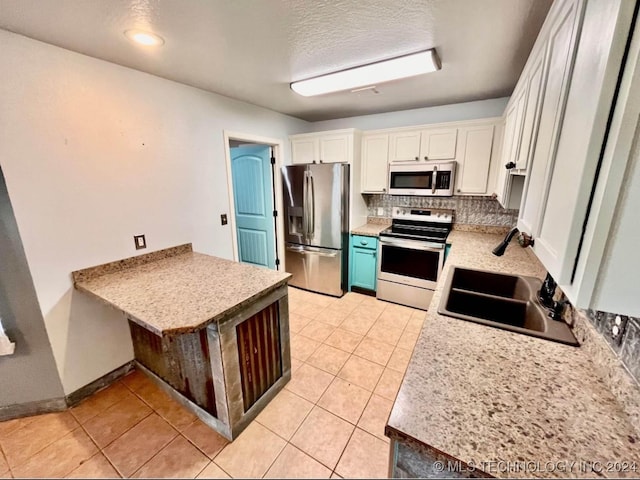 kitchen featuring white cabinetry, sink, light tile patterned flooring, and stainless steel appliances