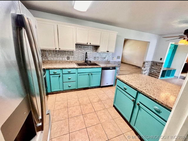 kitchen with ceiling fan, sink, stainless steel appliances, tasteful backsplash, and white cabinets