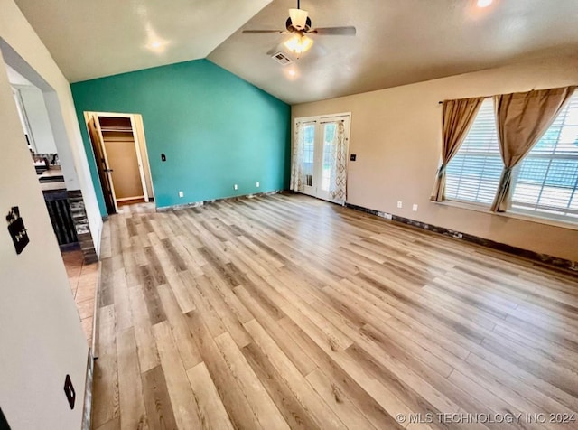 unfurnished living room with ceiling fan, vaulted ceiling, and light wood-type flooring