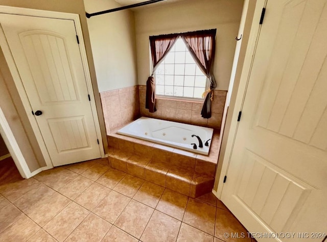 bathroom featuring tile patterned flooring and tiled bath