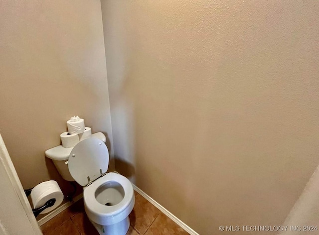 bathroom with toilet and tile patterned floors