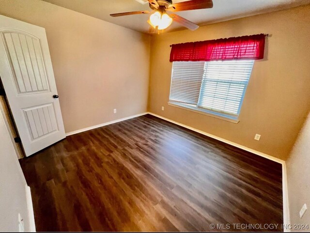 empty room featuring ceiling fan and dark wood-type flooring