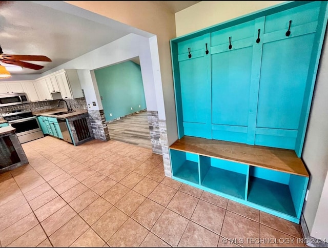 mudroom featuring light tile patterned floors, ceiling fan, and sink