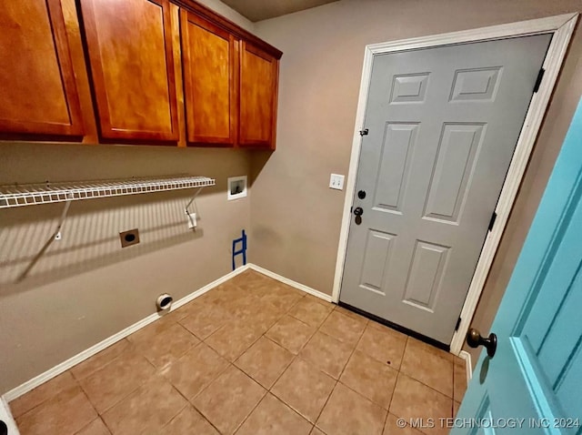 washroom featuring cabinets, hookup for a washing machine, light tile patterned floors, and hookup for an electric dryer