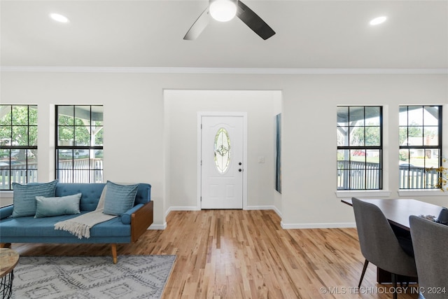 foyer entrance with ceiling fan, light hardwood / wood-style floors, and ornamental molding