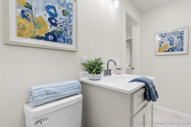 bathroom featuring tile patterned flooring, vanity, and toilet