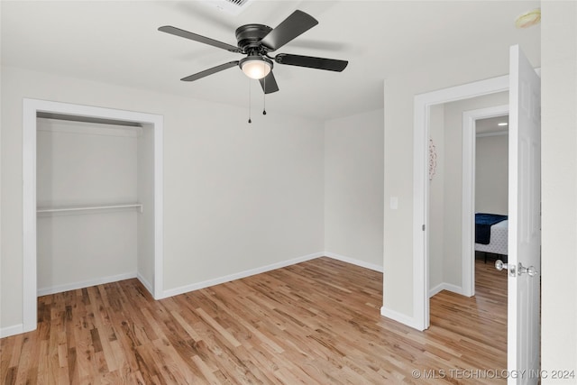 unfurnished bedroom featuring ceiling fan, a closet, and light hardwood / wood-style flooring