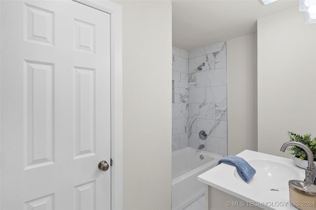 bathroom featuring vanity and tiled shower / bath