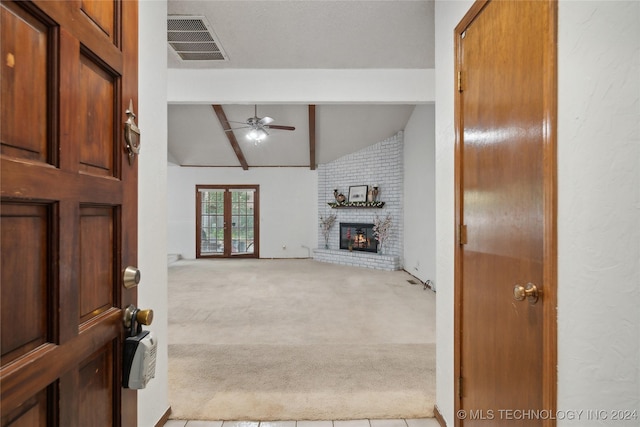 living room featuring lofted ceiling with beams, ceiling fan, light carpet, and a fireplace